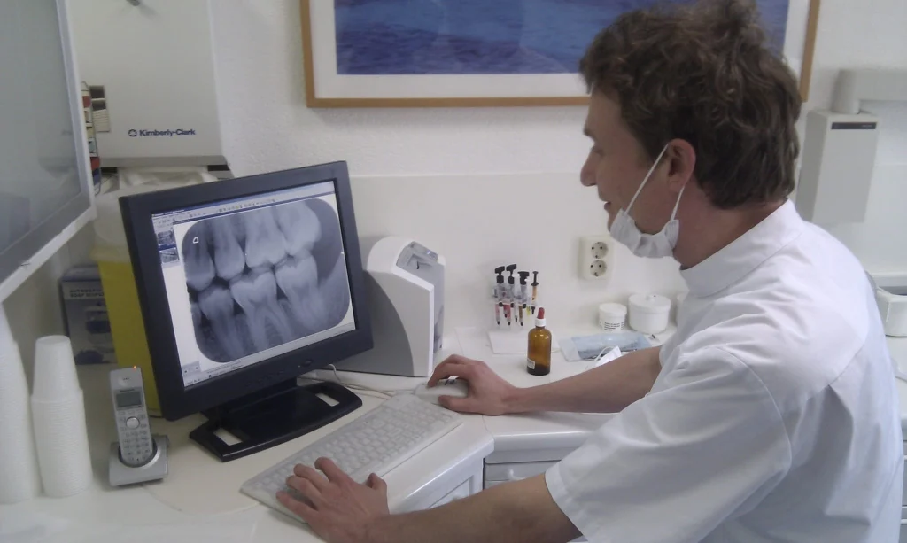 Dentist using an MMI keyboard and mouse to review dental imaging