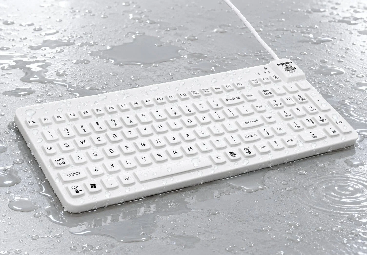 MMI Really Cool waterproof keyboard covered with water droplets on a wet worksurface